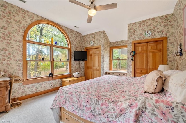 bedroom with ceiling fan, multiple windows, and carpet floors