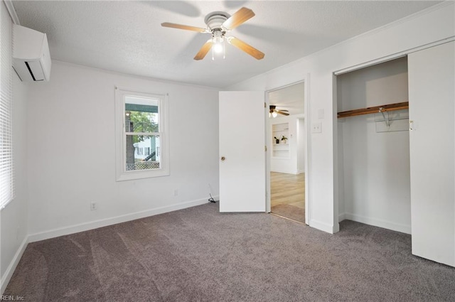 unfurnished bedroom featuring a closet, ceiling fan, an AC wall unit, and carpet