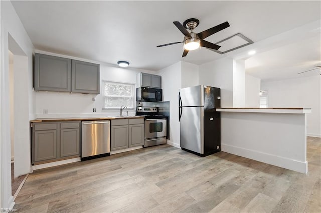 kitchen with sink, stainless steel appliances, light hardwood / wood-style flooring, and gray cabinets