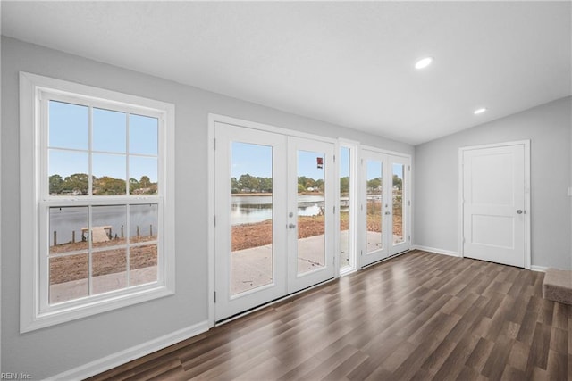 interior space with french doors, a water view, lofted ceiling, and dark hardwood / wood-style floors