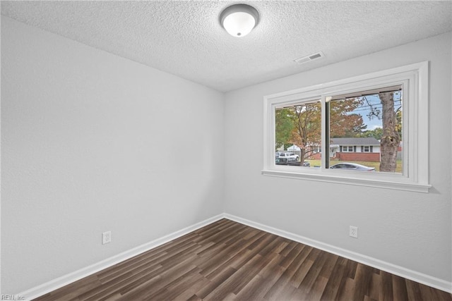 unfurnished room featuring dark hardwood / wood-style floors and a textured ceiling