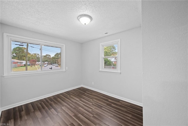 unfurnished room featuring dark hardwood / wood-style floors and a textured ceiling