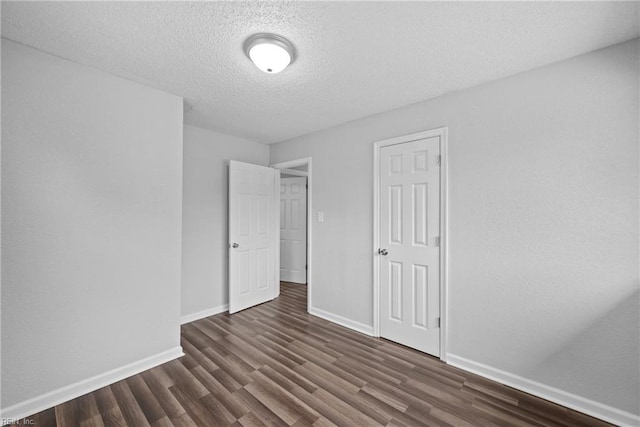 interior space with a closet, a textured ceiling, and dark hardwood / wood-style floors