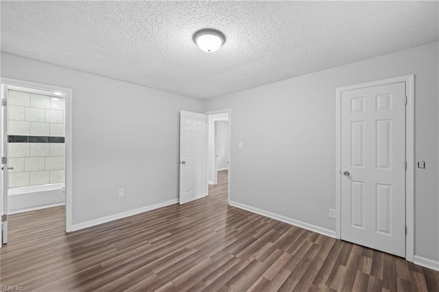 unfurnished bedroom with dark hardwood / wood-style floors and a textured ceiling