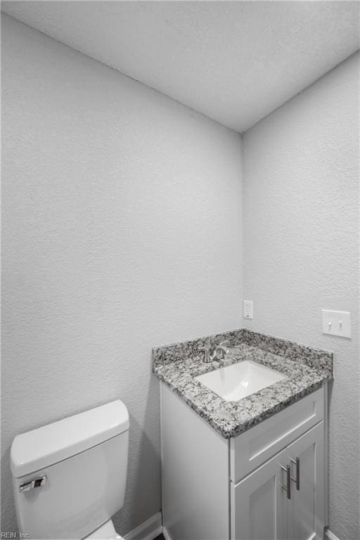 bathroom with vanity, a textured ceiling, and toilet