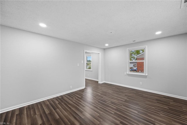 unfurnished room with a textured ceiling and dark hardwood / wood-style floors