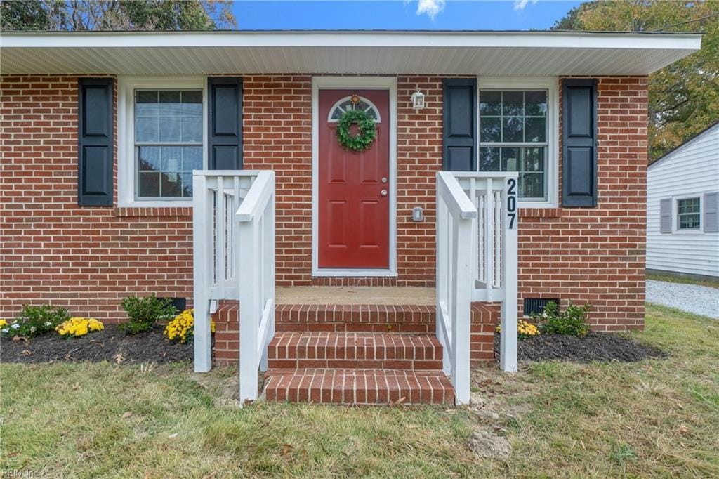 doorway to property featuring brick siding