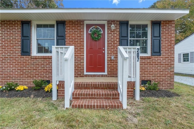 doorway to property featuring brick siding