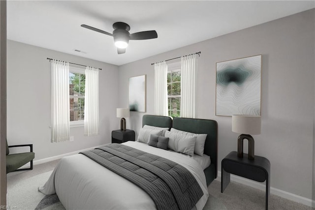 carpeted bedroom featuring multiple windows and ceiling fan