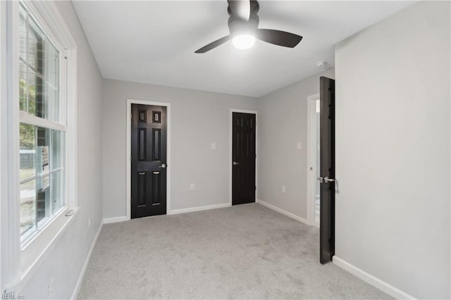 interior space with light carpet and ceiling fan