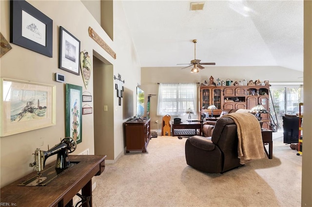 living room with ceiling fan, vaulted ceiling, and light colored carpet