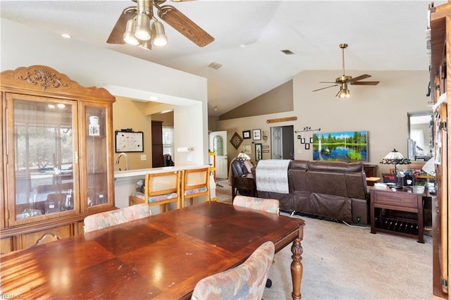 dining room with sink, vaulted ceiling, light colored carpet, and ceiling fan