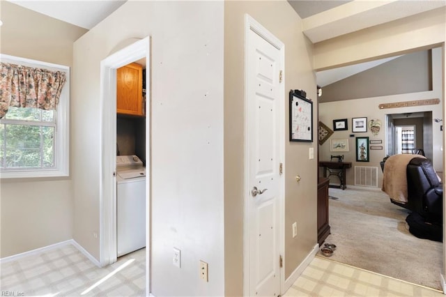 hall featuring lofted ceiling, washer / clothes dryer, and light colored carpet