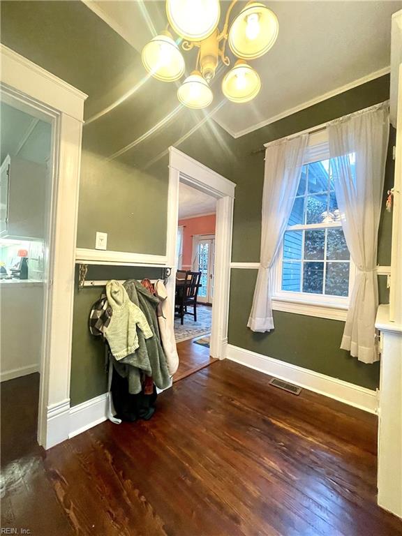 interior space featuring dark hardwood / wood-style flooring, crown molding, and a healthy amount of sunlight