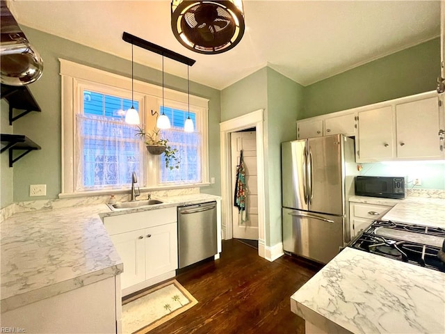 kitchen featuring hanging light fixtures, sink, white cabinets, and stainless steel appliances