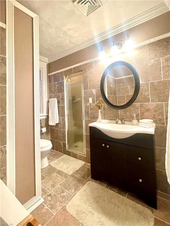 bathroom with vanity, crown molding, toilet, tile walls, and an enclosed shower