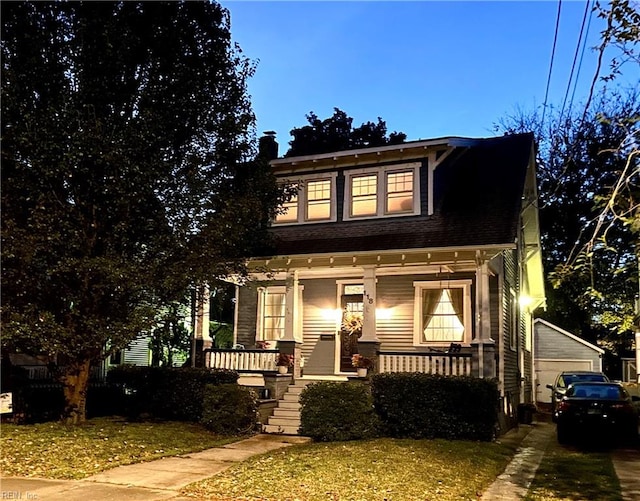 view of front of house featuring a porch, a garage, and an outdoor structure