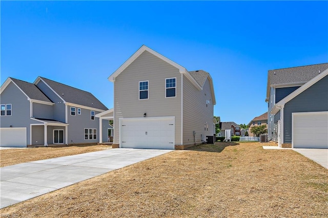 view of front of house with cooling unit, a front lawn, and a garage