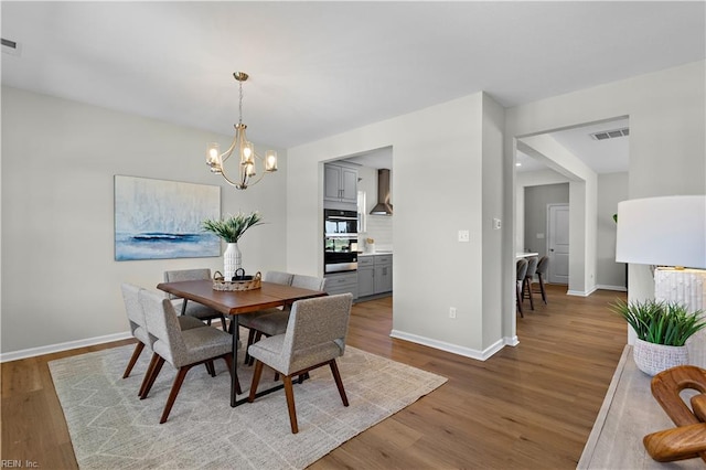 dining space featuring a notable chandelier, plenty of natural light, and hardwood / wood-style floors