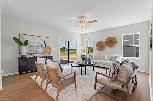 living room with ceiling fan and light hardwood / wood-style flooring