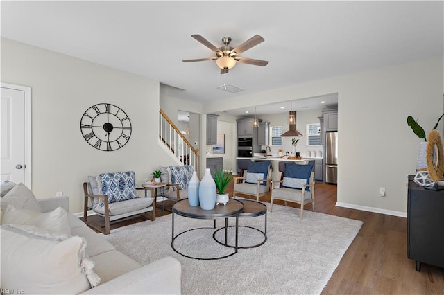 living room featuring wood-type flooring and ceiling fan