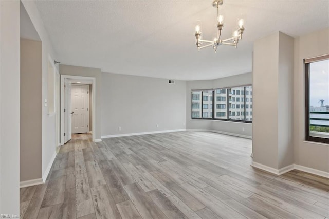 interior space with an inviting chandelier, light wood-type flooring, and plenty of natural light