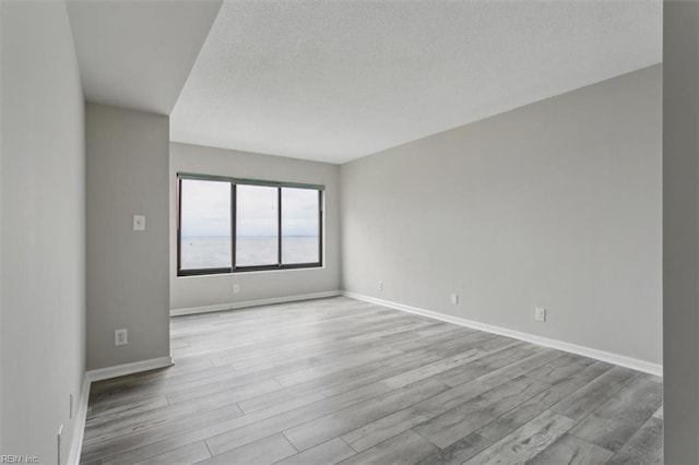 empty room featuring light hardwood / wood-style floors and a textured ceiling