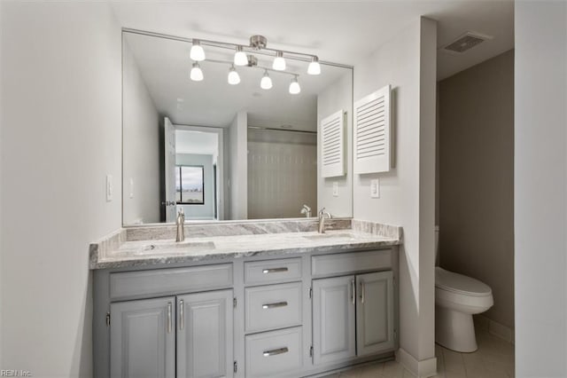 bathroom with vanity, toilet, and tile patterned floors