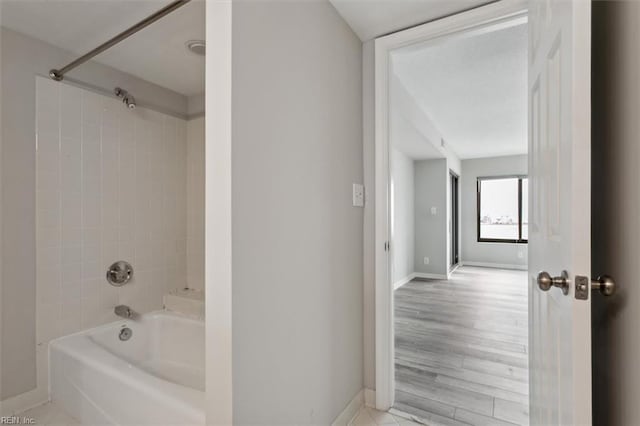 bathroom with tiled shower / bath and hardwood / wood-style floors