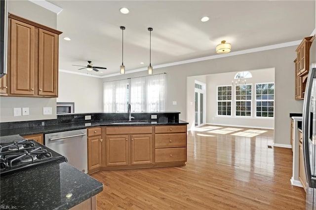 kitchen featuring dishwasher, dark stone counters, sink, and light hardwood / wood-style floors