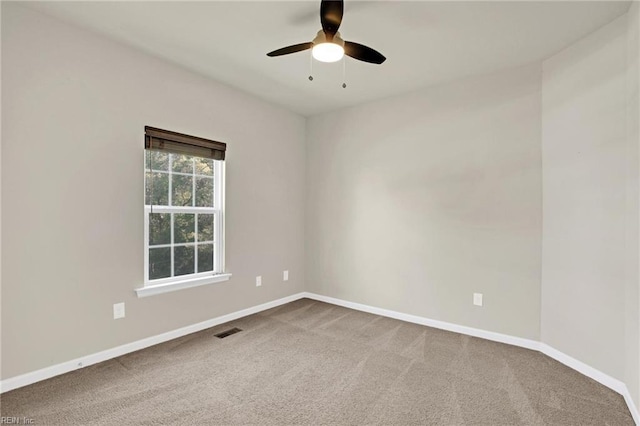 unfurnished room with ceiling fan and carpet