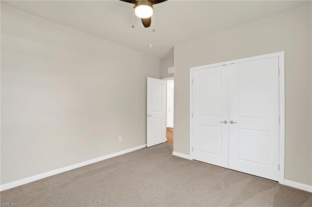 unfurnished bedroom with a closet, ceiling fan, and carpet floors