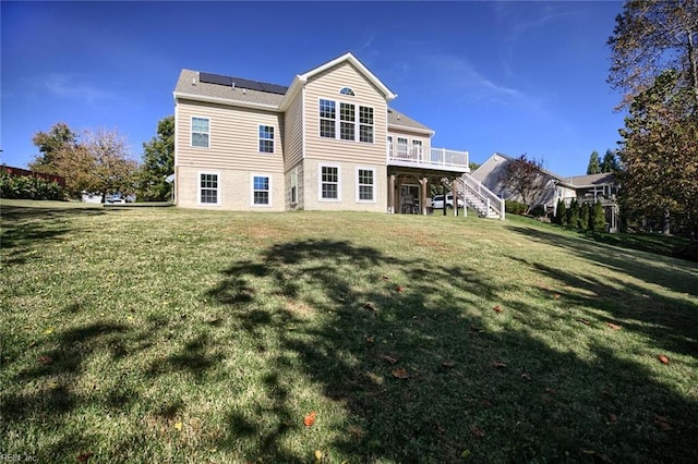 back of property with a lawn and a deck