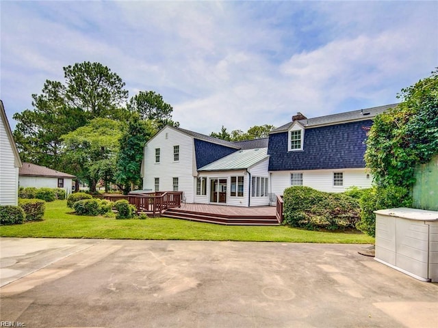 rear view of property featuring a yard and a wooden deck