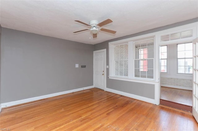 empty room with ceiling fan and light wood-type flooring