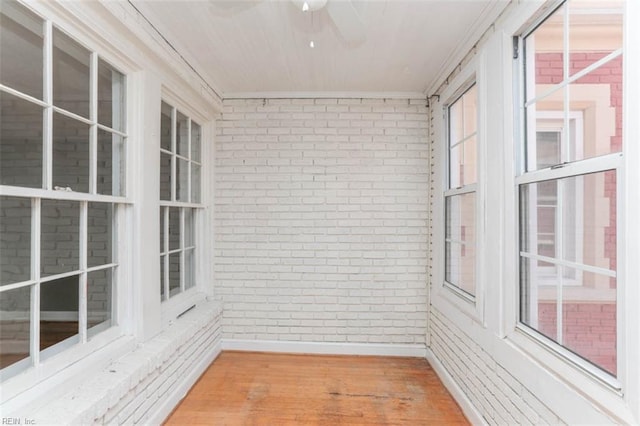 unfurnished sunroom featuring ceiling fan