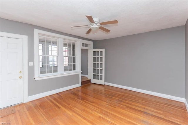 spare room with french doors, ceiling fan, and hardwood / wood-style flooring