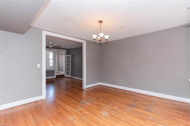 unfurnished room featuring hardwood / wood-style floors and ceiling fan with notable chandelier