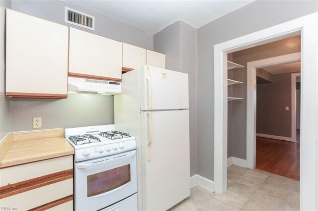 kitchen featuring extractor fan, white cabinetry, and white appliances