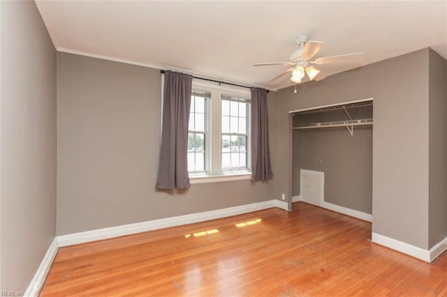 unfurnished bedroom featuring wood-type flooring, a closet, and ceiling fan