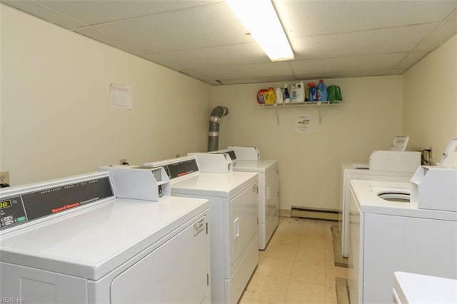 laundry room with a baseboard radiator, washing machine and dryer, and light tile patterned floors