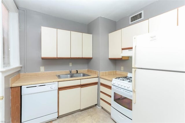 kitchen with extractor fan, sink, light tile patterned flooring, white cabinets, and white appliances