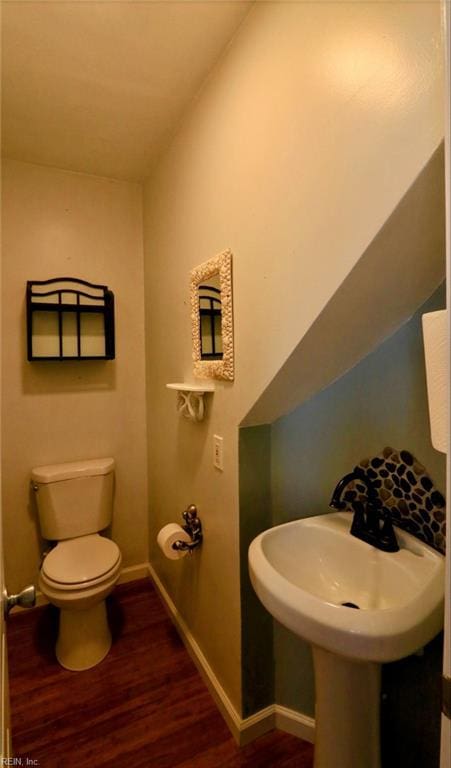 bathroom featuring sink, hardwood / wood-style floors, lofted ceiling, and toilet