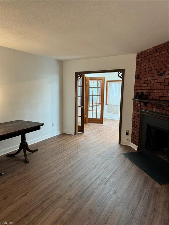 living room with a fireplace, a textured ceiling, and dark hardwood / wood-style floors