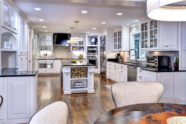 kitchen featuring hanging light fixtures, sink, a kitchen island, white cabinetry, and appliances with stainless steel finishes