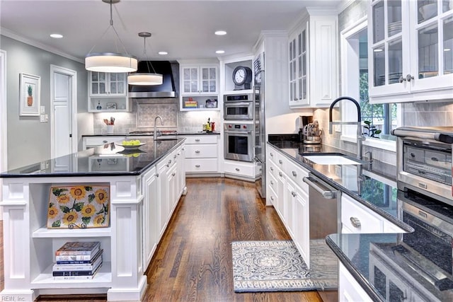 kitchen featuring sink, tasteful backsplash, a kitchen island, white cabinets, and pendant lighting