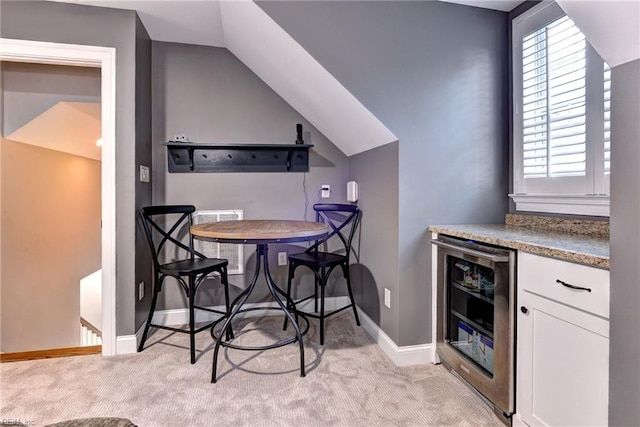 kitchen with white cabinetry, light colored carpet, lofted ceiling, and wine cooler