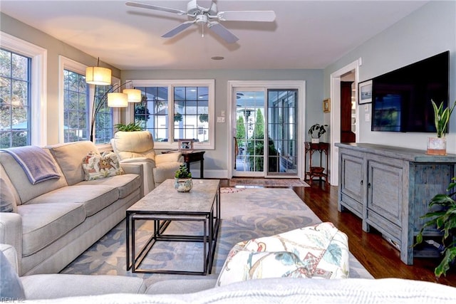 living room with dark wood-type flooring and ceiling fan