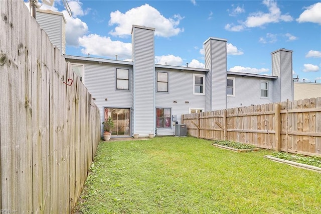 back of property featuring cooling unit and a lawn