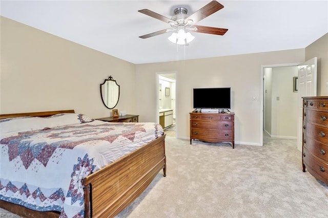 carpeted bedroom with ensuite bath and ceiling fan